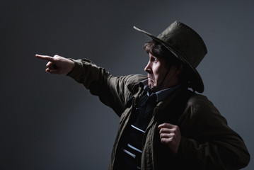 A man in a cowboy hat fright shows a finger in the direction of