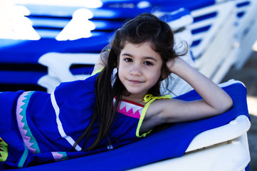 Bambina allegra sdraiata sul lettino al mare