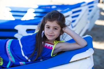 Bambina allegra sdraiata sul lettino al mare