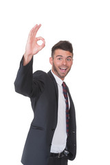 Young businessman makes OK sign - on white