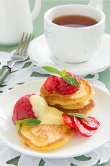 Obraz na płótnie Canvas Pancakes with strawberries, strawberry sorbet and vanilla sauce.