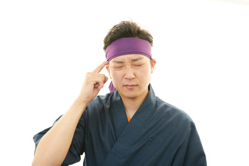 疲れた表情の寿司職人