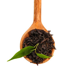 Dry black tea with green leaves in wooden spoon, isolated