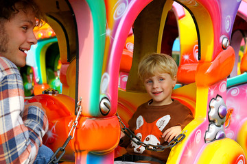 Fototapeta na wymiar Happy Father and Son on Carnival Ride