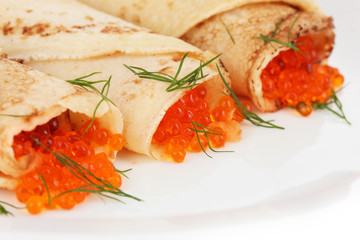 Delicious pancakes with red caviar on plate close-up