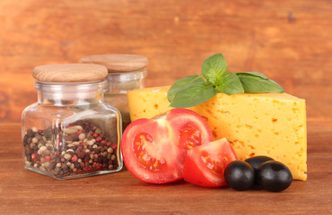 Cheese,basil and vegetables on wooden background