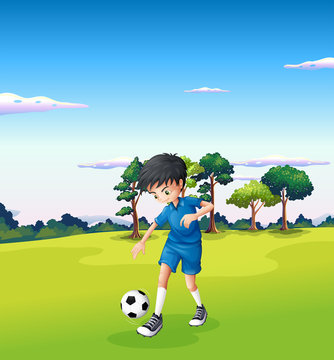 A boy playing soccer at the forest