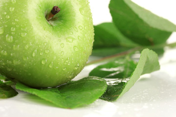 Juicy green apple with leaves, isolated on white