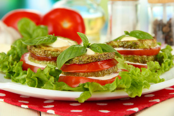 Tasty roasted marrow and tomato slices with salad leaves,