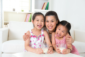 Obraz na płótnie Canvas Mother and daughters drinking milk