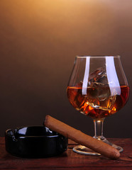 Brandy glass with ice and cigar