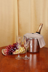 Champagne and glasses on round table on cloth background