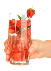 Glass of fruit drink with ice cubes in hand isolated on white
