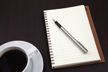 notebook with coffee cup on table