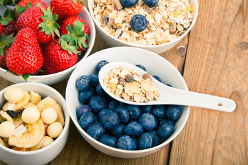 fresh blueberry, strawberry and corn flakes in white porcelain b