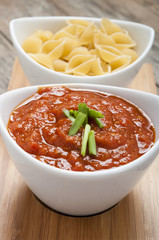 tomato sauce and pasta on wooden background