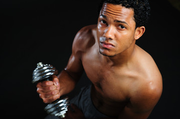 black athlete lifting weight. Male athlete performing biceps