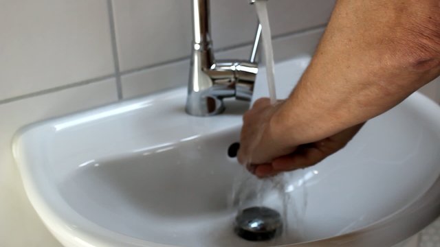 Händewaschen im Bad über Waschbecken