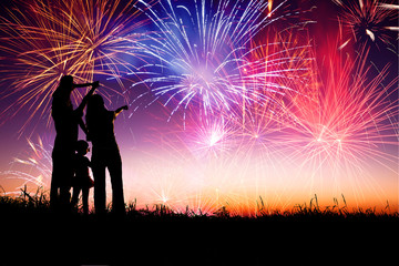 happy family standing on the hill and watching the fireworks