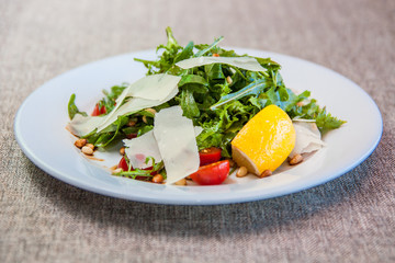 Salad with arugula, cherry tomatoes, pine nuts, parmesan cheese