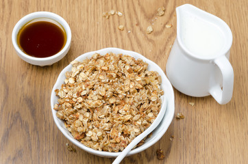 homemade muesli, jug of milk and a bowl of honey for breakfast