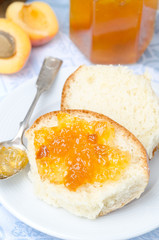 Sweet bun with apricot jam on the plate, vertical