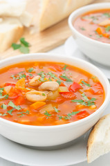 Vegetable soup with white beans in a bowl closeup