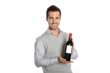 Happy winegrower showing wine bottle to camera