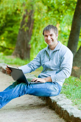 Fototapeta premium Happy man with a laptop in outdoor