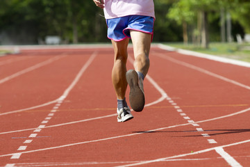 Obraz premium Male running at a track and field stadium