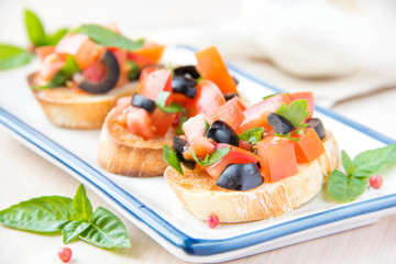 Classic Italian appetizer bruschetta with tomato, basil and blac