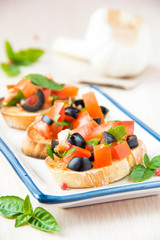 Classic Italian appetizer bruschetta with tomato, basil and blac