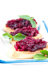 Classic Italian snack bruschetta with baked beet and fresh basil
