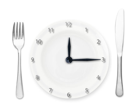 Plate - clock with fork and knife isolated on white background.