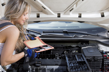 Automechaniker Frau wechselt Luftfilter vom Auto in der Hand