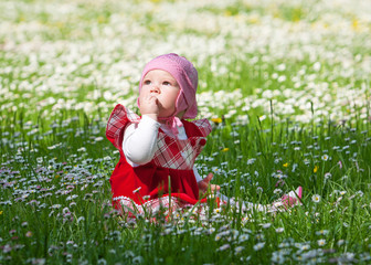 little baby on green grass and flowers
