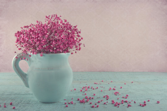 Fototapeta Pink baby's breath flowers in a blue jug