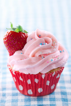 Pink cupcake with fresh strawberry and copy space