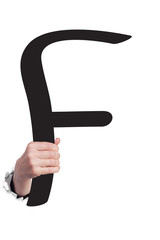 Hand breaking paper surface holding letter 'F'