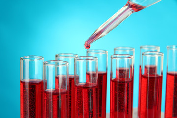 Test tubes with blood in laboratory on blue background