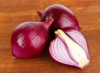 Purple onion on wooden background