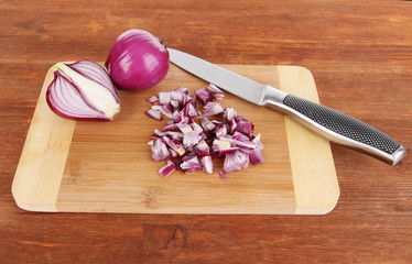 Cutting purple onion on wooden background