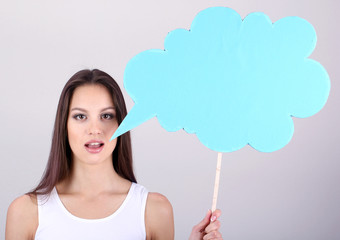 Young pretty woman with empty think bubble on grey background