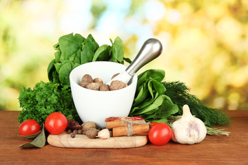 Composition of mortar, spices, tomatoes and  green herbs,
