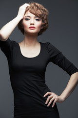 Young woman portrait standing against studio background.