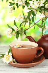 Cup of tea with jasmine, on bright background