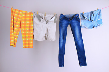 Laundry line with clothes on wall background