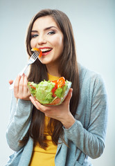 Young woman eating salad isolated