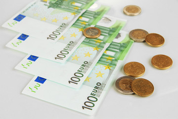 Euro banknotes and euro cents isolated on white