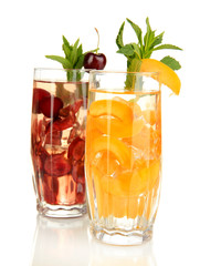 Glasses of fruit drinks with ice cubes isolated on white